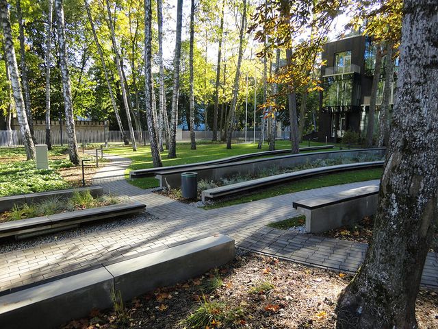 Celiņu izbūve ar klinkera bruģa segumu 280 m2, ielas un trotuāra bruģēšana 740 m2, jumta dārza ierīkošana 200 m2, sporta laukuma izveide ar gumijas segumu 75 m2, stādījumu ierīkošana 915 m2, zāliena ierīkošana 1400 m2, mazo arhitektūras formu uzstādīšana, kā arī āra koka terašu uzstādīšana 112 m2. 18