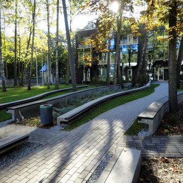 Celiņu izbūve ar klinkera bruģa segumu 280 m2, ielas un trotuāra bruģēšana 740 m2, jumta dārza ierīkošana 200 m2, sporta laukuma izveide ar gumijas segumu 75 m2, stādījumu ierīkošana 915 m2, zāliena ierīkošana 1400 m2, mazo arhitektūras formu uzstādīšana, kā arī āra koka terašu uzstādīšana 112 m2. 1